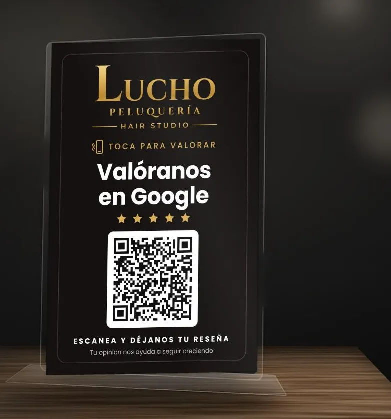 Hablador de acrílico negro de Lucho Peluquería Hair Studio con letras doradas: Valóranos en Google, cinco estrellas y código QR.